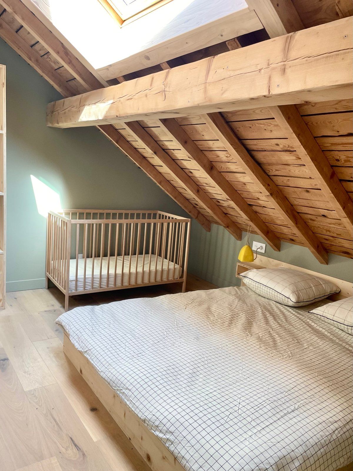 La chambre familiale : lit double et lit bébé sous la charpente