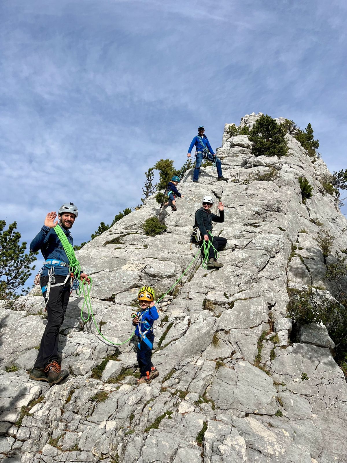 Une cordée familiale, adultes et enfants casqués, sur une arête calcaire du Vercors